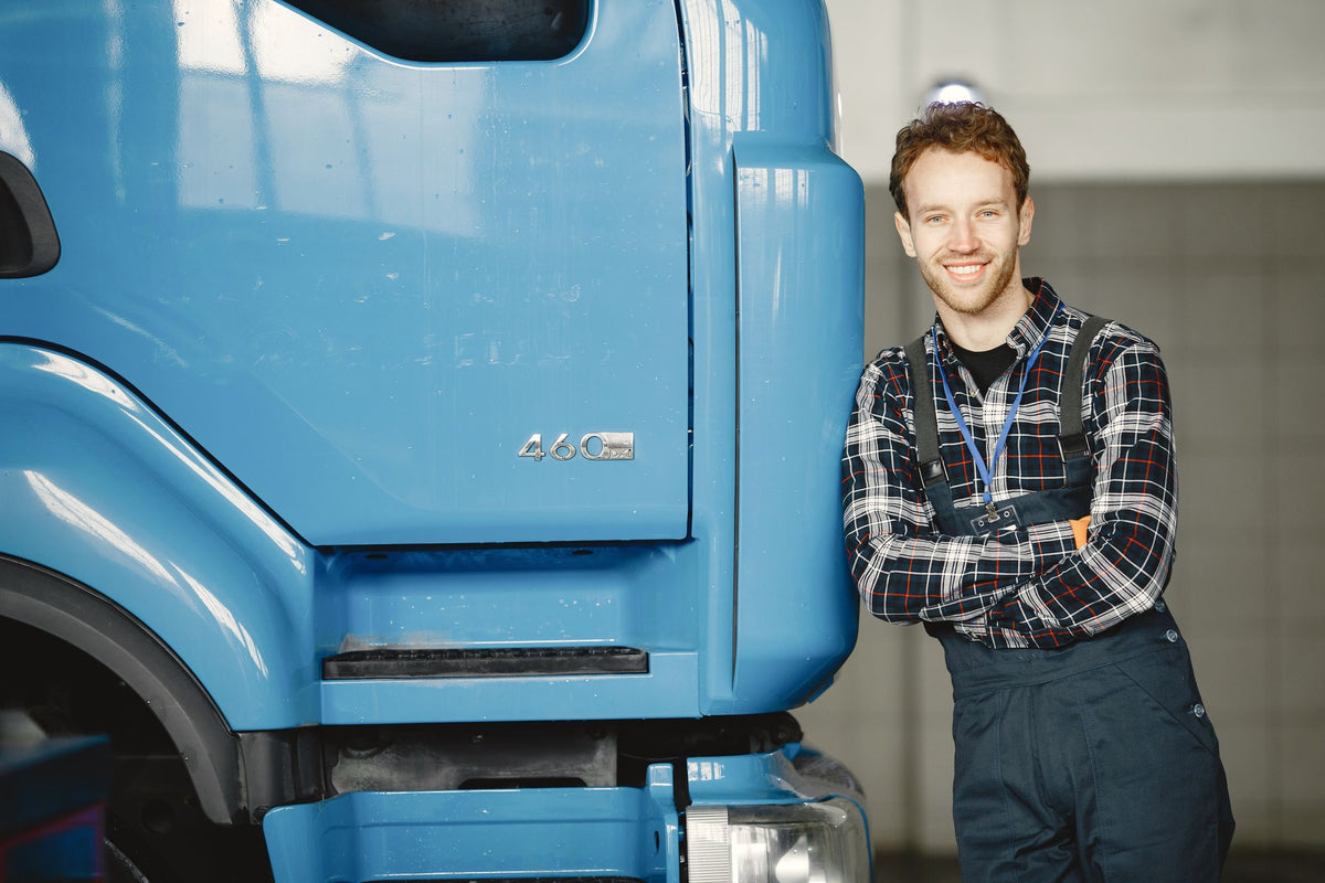 Lächelnder junger Handwerker in Latzhose in der Werkstatt (Foto: Gustavo Fring / Pexels)
